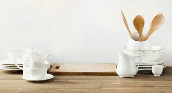 Біле кухонне начиння, посуд та інші різні білі речі для подачі на білій дерев'яній дошці . — стокове фото