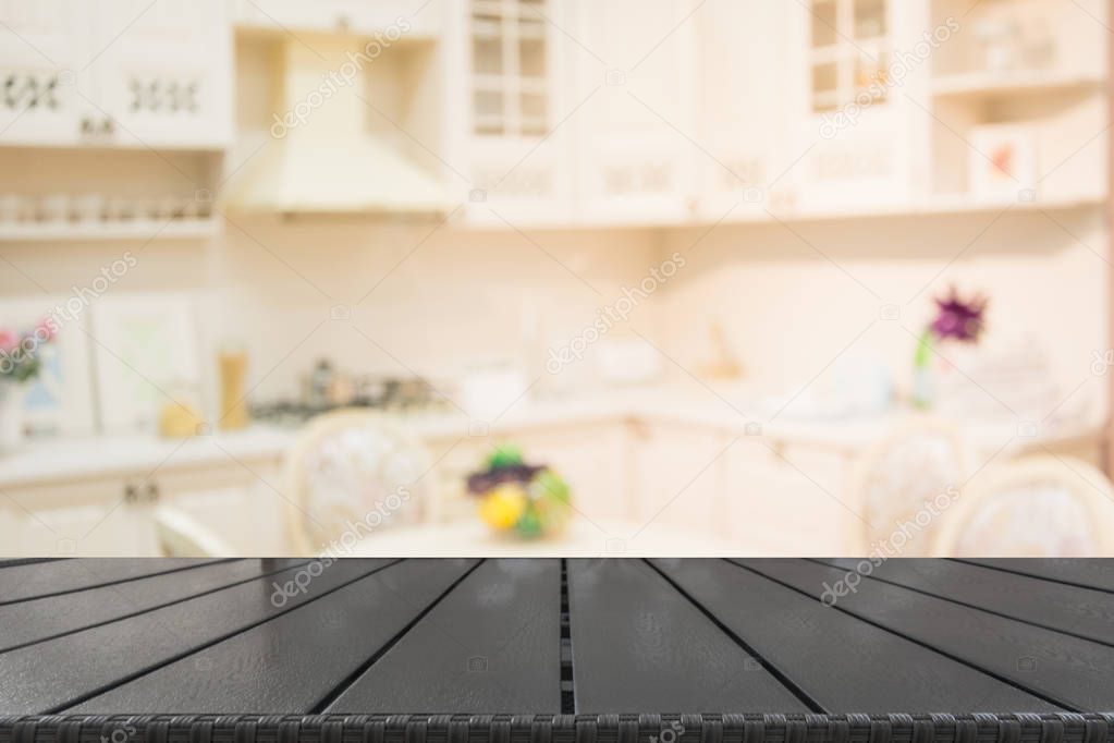 Blurred background. Empty wooden tabletop and defocused modern kitchen.