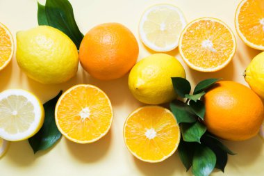 Yaz konsepti. Tropikal meyve, limon, portakal ve yeşil kümesi üzerinde sarı yapraklar. Yakın çekim. Üstten Görünüm.