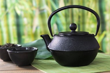 Asya yeşil çay siyah Çin su ısıtıcısı bambu hasır ile kurutulmuş yeşil çay kase ayarlayın. Çin çay kavramı.