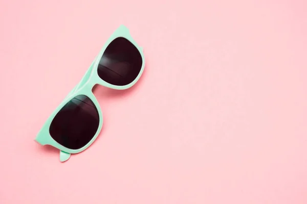 Óculos de sol pastel verde isolado em rosa punchy, vista superior. Espaço para cópia. Conceito de verão . — Fotografia de Stock