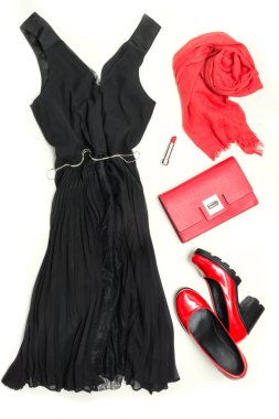 Elegant little women's black dress and red accessories for celebration or holiday. Flat lay. clipart