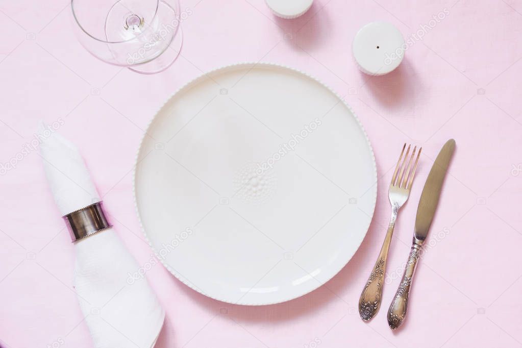 Table place setting on pink linen tablecloth. Top view. Concept.