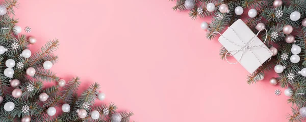 Різдвяний срібний рожевий скляний куля і ялинові гілки на рожевому. Різдвяний банер з пробілом для тексту. Вид зверху . — стокове фото