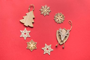 Kırmızı arka planda çelenk olarak ahşap el yapımı dekorun Noel kompozisyonu. Düz konum, üst görünüm, kopyalama alanı