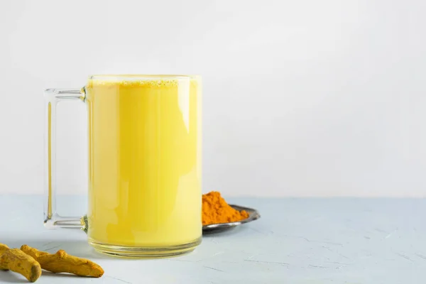 Beyaz üzerine sokağa çıkma yasağı tozu sürülmüş bir bardak ayurvedic altın zerdeçal sütlü kahve..