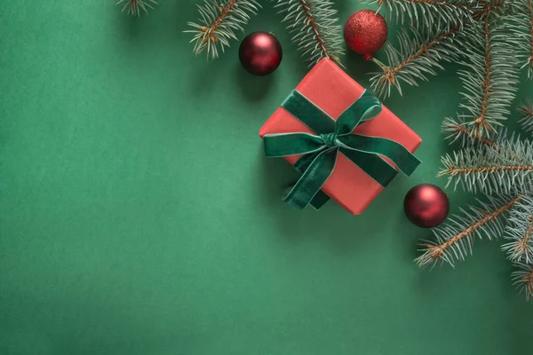 緑の背景にクリスマスツリーと赤いギフトとクリスマスの組成。グリーティングカードそうだ明けましておめでとうございます。テキストのスペース — ストック写真