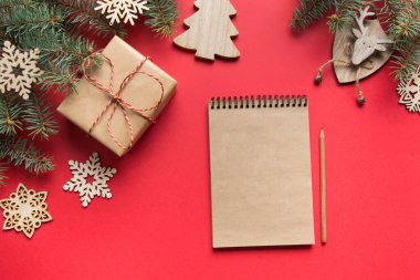 Sıfır Noel konsepti. Hedefler, kontrol listesi, yeni yıl planları. 2020 yılının dilek listesi ve kırmızı üzerine ahşap bir dekor. Üst Manzara. Düz yatıyordu.