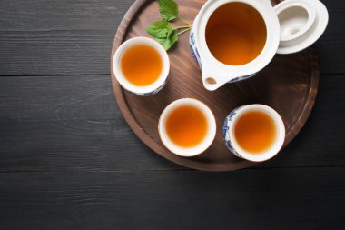 Melissa 'yla bir fincan çay ve arka planda çaydanlık. Çin çayı konsepti. Yukarıdan görüntüle.