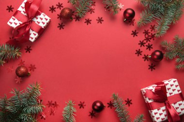Noel çerçevesi hediyeler, toplar, kırmızı arka planda köknar ağacı. Tebrik kartı. - Mutlu yıllar. Metin için boşluk