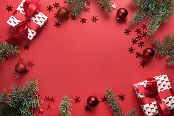 Noel çerçevesi hediyeler, toplar, kırmızı arka planda köknar ağacı. Tebrik kartı. - Mutlu yıllar. Metin için boşluk