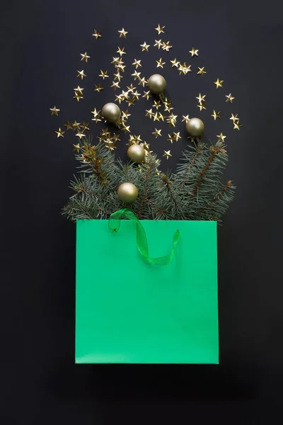Sacchetto di carta verde per lo shopping natalizio con decorazioni dorate e rami di abete . — Foto Stock
