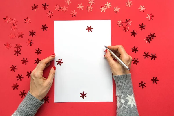 Mujer escribiendo metas, lista de verificación, planes y sueños para Año Nuevo. Lista de deseos para Navidad en rojo Decoración navideña . —  Fotos de Stock