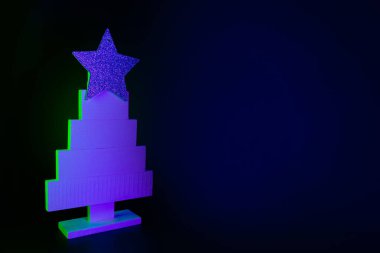 Neon mavisi içinde Noel ağacı ve siyah üzerinde yeşil ışınlar. Metin ve tatil dilekleri için alanı olan yaratıcı Xmas deseni.