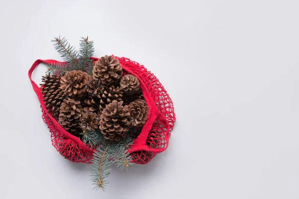 Weihnachten Zero Waste Dekor in roter Baumwolle Öko-Tasche. Zapfen und Tannenzweige für handgefertigte Gestaltung. — Stockfoto