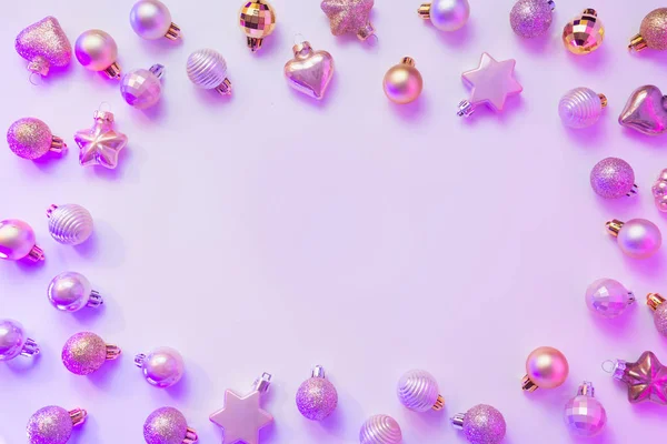 Moldura de néon em bolas de Natal de prata em raios roxos coloridos. Vista superior. Xmas . — Fotografia de Stock