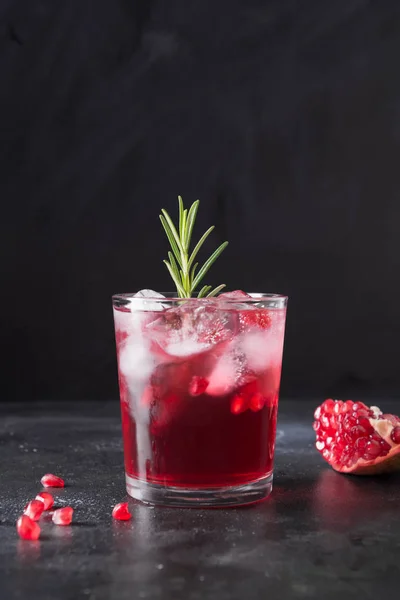 Granatäpple jul cocktail med rosmarin, champagne, club soda på svart. Närbild. — Stockfoto