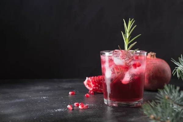Pomegranate Christmas cocktail with rosemary, champagne, club soda on black. Close up. — Stock Photo, Image