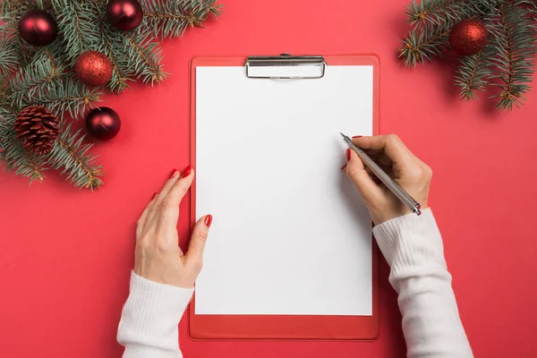 Vrouw schrijft doelen, checklist, plannen en dromen voor Nieuwjaar. Een verlanglijstje voor Kerstmis. Bovenaanzicht en ruimte voor tekst. Vlakke plaat. — Stockfoto