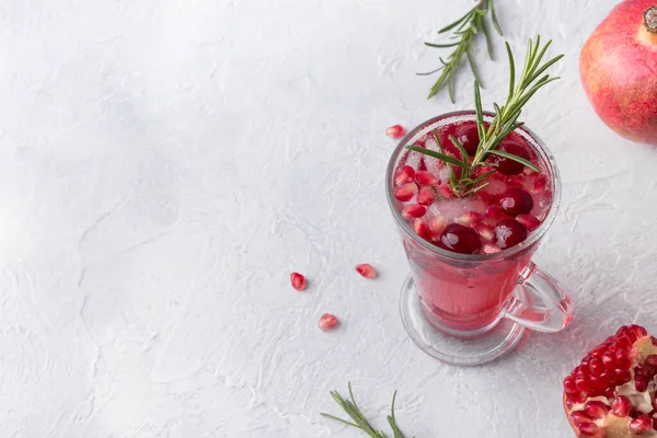 Granatäpple jul cocktail med rosmarin, tranbär, champagne, club soda på grått betongbord. Juldryck. — Stockfoto