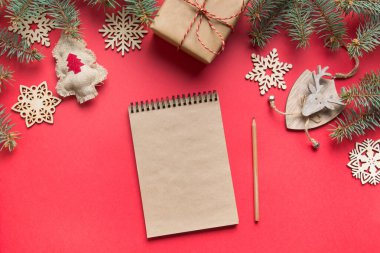 Sıfır Noel konsepti. Hedefler, kontrol listesi, yeni yıl planları. 2020 yılının dilek listesi ve kırmızı üzerine ahşap bir dekor. Üst Manzara. Düz yatıyordu.