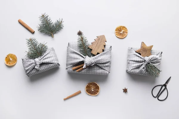 Doğal dekorlu gri tekstile sarılı Noel hediyeleri. Sürdürülebilir hediyeler. Sıfır kayıp. Xmas çevre tatili. Geleneksel Japon Furoshiki tarzı. Yukarıdan bak. Düz yatıyordu.