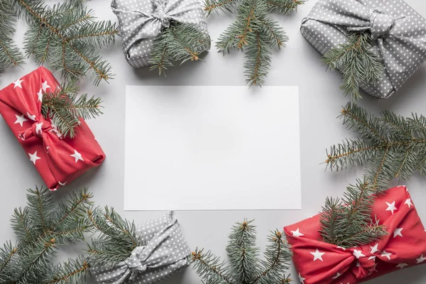 Frontera de regalos de Navidad envueltos en textil con decoración natural. Regalos sostenibles. Cero residuos. Vacaciones ecológicas de Navidad. Estilo japonés Furoshiki. Vista desde arriba. Puesta plana . —  Fotos de Stock