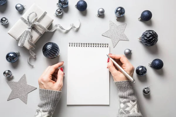 Mujer escribe metas, lista de verificación, planes y sueños para el Año Nuevo. Lista de deseos para Navidad en la decoración clásica azul de vacaciones . —  Fotos de Stock