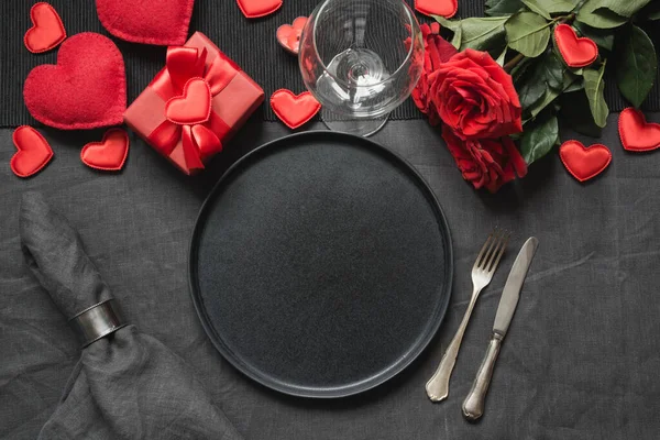 День святого Валентина або день народження. Таблиця вирівнювання з букетом червоної троянди на чорному лляному скатертині. — стокове фото