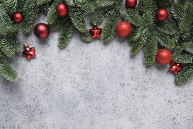Noel kış kemeri, köknar dalları, doğal gri arka planda kırmızı toplar. Xmas tebrik kartı. - Mutlu yıllar. Mesaj için yer var. Yukarıdan bak, düz yat.