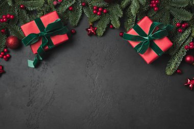 Kırmızı hediyeli Noel kompozisyonu, köknar dalları, siyah toplar. Mutlu Noel kartları. Kış tatili - Mutlu yıllar. Mesaj için yer var. Yukarıdan bak, düz yat.
