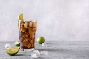 Kokteyl Küba Libre ya da Long Island Buzlu Çayı rom, kola, kireç ve buzlu gri taş masa.