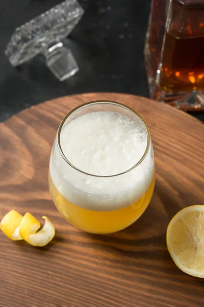 Whiskey sour cocktail - bourbon med citronsaft, sockersirap eller honung och äggvita blandat i glas. Vertikal inriktning. — Stockfoto