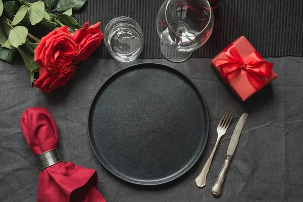 День Святого Валентина или праздничный ужин. Элегантный стол с красной розой на скатерти из черного льна . — стоковое фото
