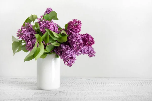 Buquê de flores lilás roxas em vaso branco. Espaço para texto . — Fotografia de Stock