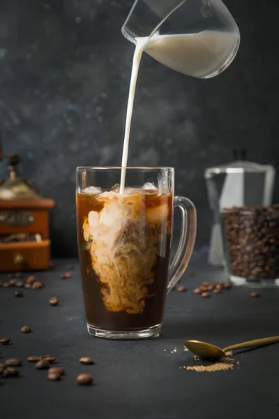 Кофе со льдом в стакане с молоком на черный — стоковое фото