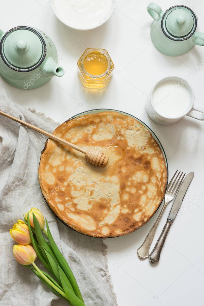 Tasty russian breakfast pancakes, milk, sour cream, honey. Springtime. Shrovetide.