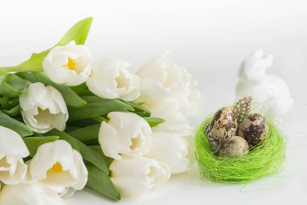 Concepto de Pascua. Tulipanes blancos, huevos de codorniz en el nido en blanco. Espacio — Foto de Stock