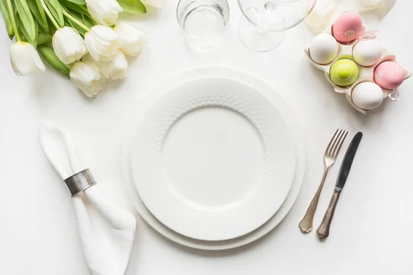 Пасхальний стіл з білими тюльпанами, яйцями на білому столі. Вид зверху . — стокове фото