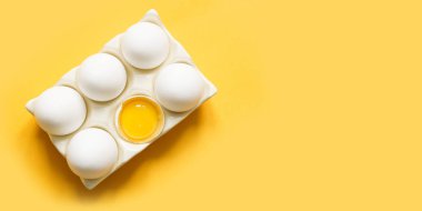 Porselen kutuda sarı üzerine organik beyaz tavuk yumurtası. Üst görünüm.