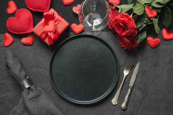 День святого Валентина або день народження. Романтичний стіл з червоною трояндою на чорному полотні скатертини. — стокове фото