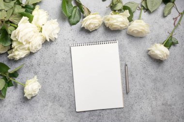 Gri üzerine boş ve buket beyaz güller. Kopyalama alanı olan üst görünüm.