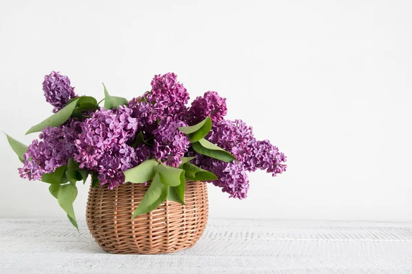 Cesta de flor lilás em tábua de madeira branca. Dia das mães e das mulheres . — Fotografia de Stock