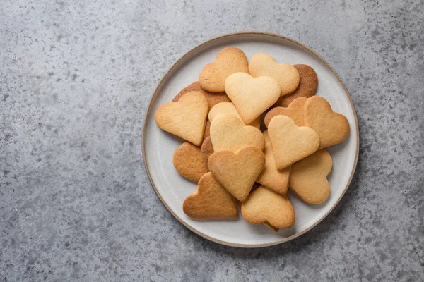 Biglietto di auguri per San Valentino con biscotti a forma di cuore e tazza di caffè sul tavolo grigio in pietra . — Foto Stock