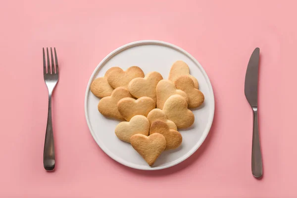 Biscotti a forma di cuore di San Valentino in piatto. Apparecchiatura tavola su sfondo rosa. Concetto. Vista dall'alto. Posa piatta . — Foto Stock