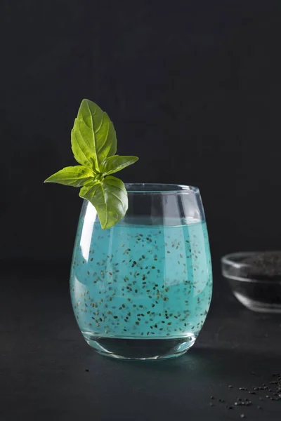 Bazsalikommagos kék ital trópusi gyümölcslével üvegben, feketén. Közelről.. — Stock Fotó