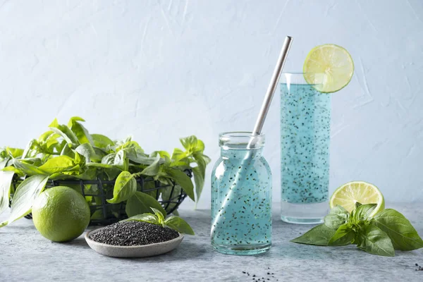 Kék koktél bazsalikommaggal és trópusi gyümölcslé üvegben fényben. Közelről.. — Stock Fotó