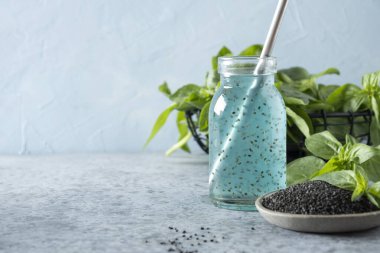 Fesleğen tohumlu mavi kokteyl ve ışıkta tropikal meyve suyu. Kapat..