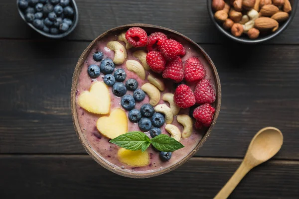 Batido casero con frambuesas decoradas con plátano en un bol de coco oscuro. De cerca. . — Foto de Stock