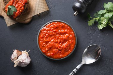 Lezzetli ayvar. Sebze sosu ya da siyah üzerine fırında kırmızı dolma biber havyarı. Balkan mutfağı. Yatay oryantasyon. Üst görünüm.